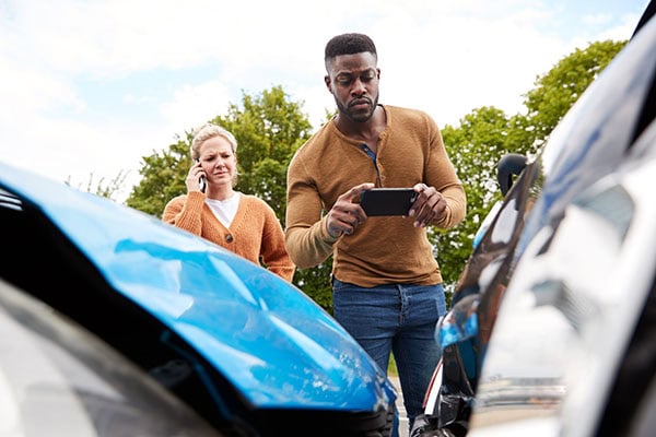 Two people exchanging info at an auto accident