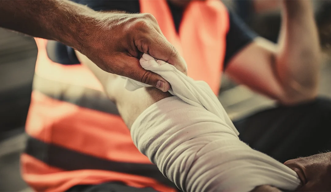 Worker's arm being wrapping in a bandage